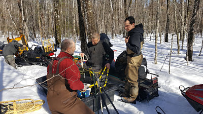 Men loading gear onto snow mobiles